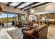 Spacious living area with leather furniture, exposed beams, and an open flow to the kitchen at 10902 N 138Th Pl, Scottsdale, AZ 85259