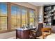 Home office featuring a large desk, leather chair, and views of the desert landscape at 10902 N 138Th Pl, Scottsdale, AZ 85259
