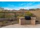 Outdoor kitchen area with built-in barbecue grill and stunning mountain views at 10902 N 138Th Pl, Scottsdale, AZ 85259