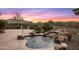 Pool area with lush desert landscaping and a rock waterfall, perfect for relaxation at 10902 N 138Th Pl, Scottsdale, AZ 85259