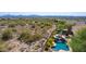 Aerial view of a home with a pool and desert surroundings, showcasing the serene desert lifestyle at 10999 E Acoma Dr, Scottsdale, AZ 85255