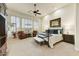 Spacious bedroom featuring a ceiling fan, neutral carpet, natural lighting, and two leather chairs at 10999 E Acoma Dr, Scottsdale, AZ 85255