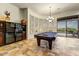 Billiards room with a wine fridge, elegant chandelier, and easy access to the outdoor patio at 10999 E Acoma Dr, Scottsdale, AZ 85255