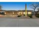 Inviting desert home with stone accents, three-car garage, and lush, low-maintenance landscaping at 10999 E Acoma Dr, Scottsdale, AZ 85255