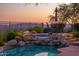 Backyard oasis with a beautiful pool and hot tub with rock accents, plus a patio dining area at 10999 E Acoma Dr, Scottsdale, AZ 85255