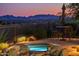 Outdoor living space with a hot tub with stone accents and a patio set, surrounded by desert views at 10999 E Acoma Dr, Scottsdale, AZ 85255
