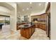 Open-concept kitchen with granite countertops, wooden cabinets, and a large island at 10999 E Acoma Dr, Scottsdale, AZ 85255