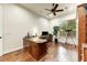 Home office with hardwood floors, large wood desk, and bright natural lighting at 10999 E Acoma Dr, Scottsdale, AZ 85255