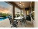 Covered patio features an outdoor dining area and a stunning pool view with a built-in television at 10999 E Acoma Dr, Scottsdale, AZ 85255