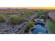 Backyard oasis featuring a sparkling pool, hot tub, patio seating, and views of the surrounding desert landscape at 10999 E Acoma Dr, Scottsdale, AZ 85255