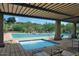 Pool view from underneath a shaded pergola with lounge chairs surrounding the pool at 10999 E Acoma Dr, Scottsdale, AZ 85255