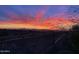 Stunning sunset view overlooking the desert landscape and mountains from the backyard patio with metal railing at 10999 E Acoma Dr, Scottsdale, AZ 85255