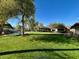 Lush backyard with a mature trees, swimming pool and expansive grassy area perfect for outdoor living and relaxation at 11021 N 74Th St, Scottsdale, AZ 85260