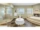 Luxurious bathroom with glass-enclosed shower, soaking tub, and decorative tile accents at 11021 N 74Th St, Scottsdale, AZ 85260