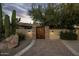 Inviting desert home with a lighted courtyard entry featuring a custom wood gate and beautiful desert landscaping at 11021 N 74Th St, Scottsdale, AZ 85260
