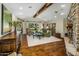 Inviting living room featuring exposed wood beams, stone fireplace, and scenic backyard views at 11021 N 74Th St, Scottsdale, AZ 85260