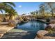 Stunning pool with rock features and lush landscaping, creating a relaxing backyard oasis at 11021 N 74Th St, Scottsdale, AZ 85260
