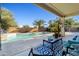 Inviting covered patio overlooking a swimming pool and lush tropical landscaping at 11933 N 140Th Ln, Surprise, AZ 85379