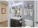 Bathroom features a single sink vanity, decorative mirror, and stylish wall decor, complemented by neutral tiling at 11933 N 140Th Ln, Surprise, AZ 85379