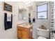 Well-lit bathroom featuring a single sink vanity, a framed mirror, and a toilet in a cozy space at 11933 N 140Th Ln, Surprise, AZ 85379