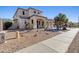 Attractive home exterior with stone landscaping and covered porch entry at 11933 N 140Th Ln, Surprise, AZ 85379