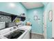Well-organized laundry room features modern appliances, decorative shelving, and tiled flooring for easy maintenance at 11933 N 140Th Ln, Surprise, AZ 85379