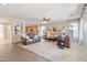 Spacious living room with plush sofas, a ceiling fan, and seamless flow into the kitchen at 11933 N 140Th Ln, Surprise, AZ 85379