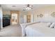 Comfortable primary bedroom with a plush bed, ceiling fan, and a glimpse into the en-suite bathroom at 11933 N 140Th Ln, Surprise, AZ 85379