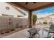 A covered back patio with stone flooring overlooks the backyard and mature citrus tree at 12814 W Sells Dr, Litchfield Park, AZ 85340