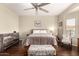 Comfortable bedroom with hardwood floors, ceiling fan, and a decorative bench at 12814 W Sells Dr, Litchfield Park, AZ 85340