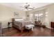 Cozy bedroom with hardwood floors, ceiling fan, and large windows providing natural light at 12814 W Sells Dr, Litchfield Park, AZ 85340