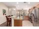 Spacious kitchen featuring stainless steel appliances, tile floors, and a large counter with seating at 12814 W Sells Dr, Litchfield Park, AZ 85340