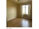 Bedroom with neutral paint, wood-look floors and a large window covered in light filtering curtains at 14930 N Gil Balcome Ct, Surprise, AZ 85379