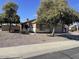 Exterior view of a single-story home with mature trees and low-maintenance landscaping at 14930 N Gil Balcome Ct, Surprise, AZ 85379