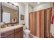 Bathroom featuring a vanity with solid surface counters, matching shower curtain and decorative wall art at 16712 S 175Th Ln, Goodyear, AZ 85338