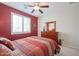 Bedroom with a ceiling fan, red accent wall, and dresser at 16712 S 175Th Ln, Goodyear, AZ 85338
