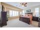 A well-lit bedroom featuring a large bed, plantation shutters, and ample natural light at 16712 S 175Th Ln, Goodyear, AZ 85338