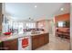 Kitchen area with stainless steel dishwasher and sink, open to living room with sliding glass doors at 16712 S 175Th Ln, Goodyear, AZ 85338