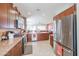 Open-concept kitchen featuring stainless appliances, granite countertops and dark wood cabinets at 16712 S 175Th Ln, Goodyear, AZ 85338