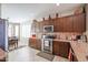 Well-lit kitchen with stainless steel appliances and dark wood cabinetry adjacent to the dining area at 16712 S 175Th Ln, Goodyear, AZ 85338