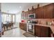 This kitchen boasts stainless steel appliances and dark wood cabinets near the dining area at 16712 S 175Th Ln, Goodyear, AZ 85338