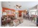 Bright living room featuring a leather sofa, ceiling fan, and an open layout to the kitchen area at 16712 S 175Th Ln, Goodyear, AZ 85338