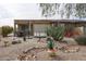 Lush backyard featuring desert landscaping, rock features, and a cozy patio area at 17662 W Cedarwood Ln, Goodyear, AZ 85338