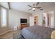 Bedroom with neutral walls, a ceiling fan, a TV, and an ensuite bathroom at 17662 W Cedarwood Ln, Goodyear, AZ 85338