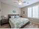 Cozy bedroom with wood-look tile flooring, ceiling fan, plantation shutters and queen bed at 17662 W Cedarwood Ln, Goodyear, AZ 85338