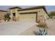 Inviting home exterior with a large two car garage, desert landscaping, and stone accents at 17662 W Cedarwood Ln, Goodyear, AZ 85338