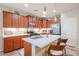A kitchen featuring updated appliances, a center island with seating, and beautiful wood cabinets at 17662 W Cedarwood Ln, Goodyear, AZ 85338