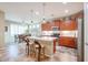 Well-lit kitchen featuring stainless steel appliances, tile floors, wooden cabinets and a breakfast bar at 17662 W Cedarwood Ln, Goodyear, AZ 85338
