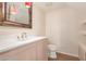 Bright bathroom features a marble countertop, wooden cabinets, framed mirror, and modern fixtures at 2012 W Lawrence Rd, Phoenix, AZ 85015