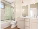 Bright bathroom features double vanity, a toilet, and glass-enclosed bathtub with shower at 2012 W Lawrence Rd, Phoenix, AZ 85015